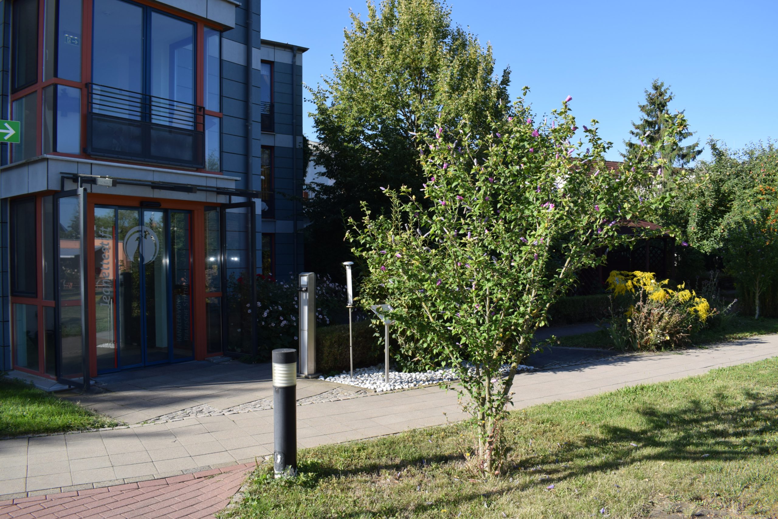 Eingang vom Jeanettestift in Bernburg mit Sträuchern und Bäumen