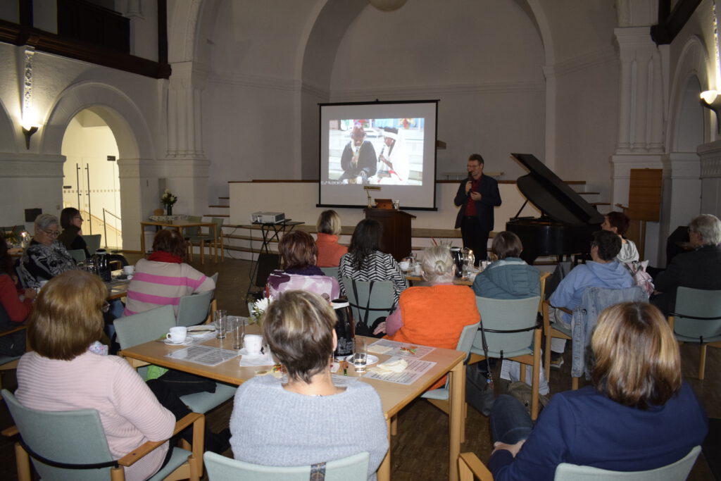 Frauenfrühstück 2025 im Gemeindehaus Bernburg, Gastredner spricht und Bilder aus Äthiopien sind zu sehen.