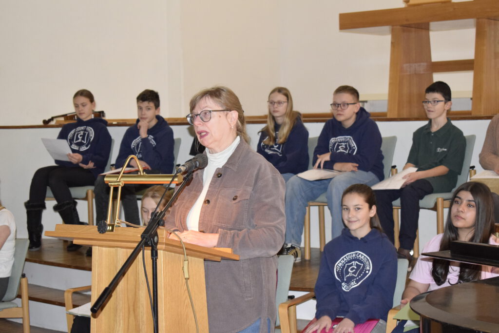Caroliner lesen für Seniorinnen und Senioren, die Deutschlehrerin spricht zu den Bewohnern