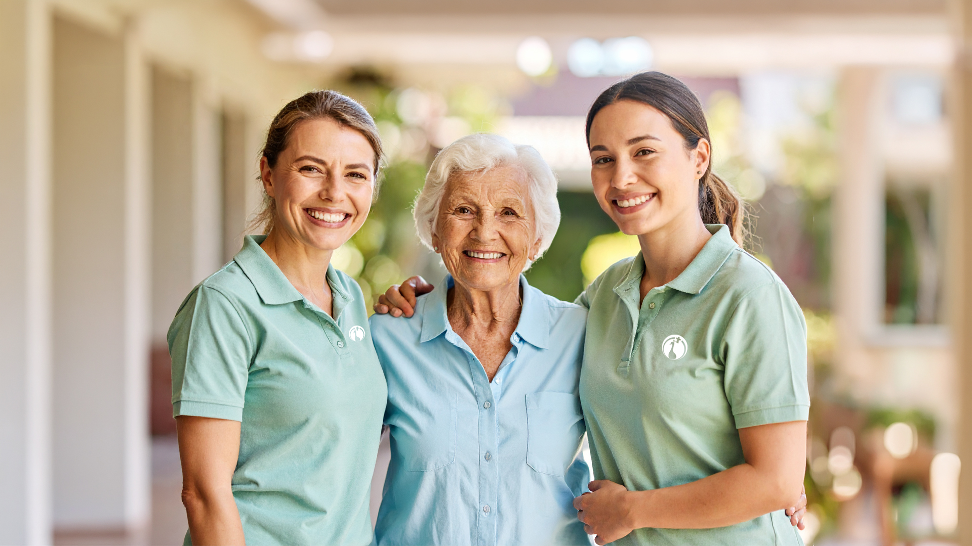 Zwei Pflegefachkräfte mit einer Seniorin