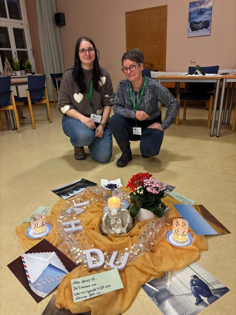Zwei ehrenamtliche Mitarbeiterinnen des Hospizdienstes Eisleben hocken vor einem dekorierten Boden