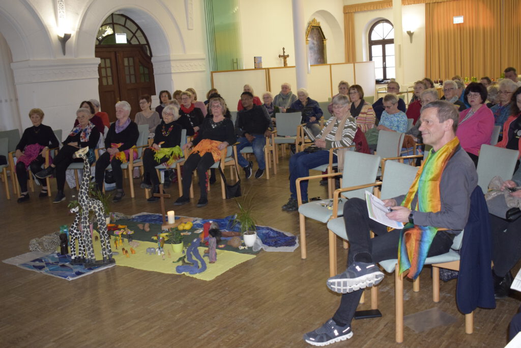 Weltgebetstag 2026 - Kommt! Teilt eure Last. - Besucher lauschen den Texten.